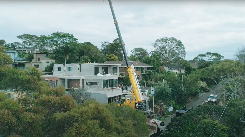 Mobile crane lifting over houses on a residential project
